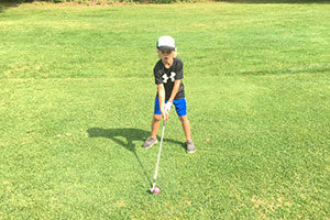 An image of a boy in his golf stance.