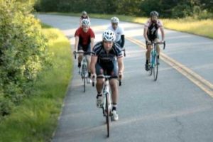 An image of 5 cyclists riding on a road.