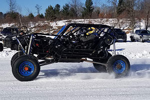 An image of an ATV driving on a path covered in snow.
