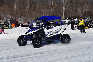 An image of an ATV driving on a snow packed path.